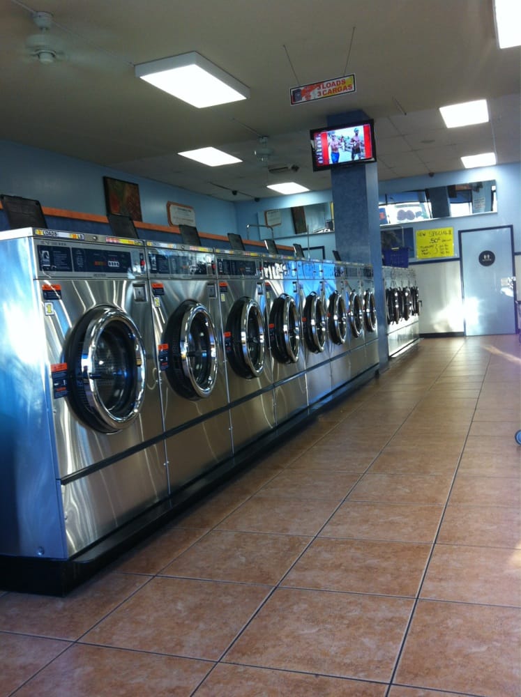 Clean laundromat with a row of commercial washing machines